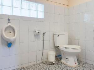 a bathroom with a toilet and a urinal on the wall at Chompor villa farmstay in Chiang Dao +22 photos