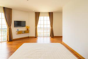 a large living room with windows and a television at Ocean Hill Lodge Phú Quốc in Phu Quoc