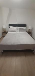 a large bed in a room with two lamps at Old Town Lux in Baška