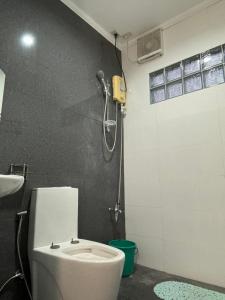 a bathroom with a white toilet and a shower at Three Bedrooms Comfort Zone Guesthouse in Bengcag +33 photos