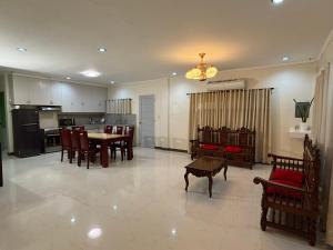 a kitchen and living room with a table and chairs at Comfort Haven Guesthouse in Bengcag