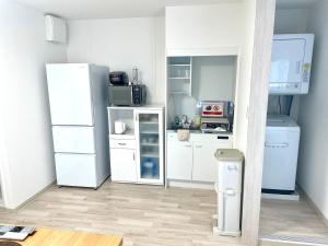 una cucina con elettrodomestici bianchi in una camera di Villa Hayabusa ad Osaka