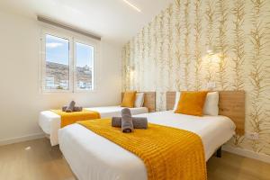 2 Betten in einem gelb-weißen Zimmer in der Unterkunft HORIZON VACATION HOME - Yucatán Coastal Oasis in Mogán + 42 Fotos