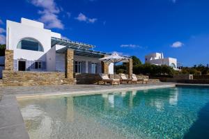 a villa with a swimming pool and a house at Soho Villa in Paros in Chrissi Akti