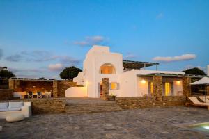 a villa with a swimming pool at dusk at Soho Villa in Paros in Chrissi Akti