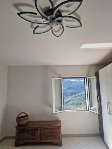a ceiling fan in a living room with a window at Casa Ofelia in Colledimezzo