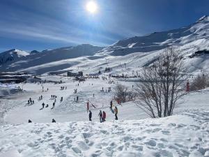 grupa osób jeżdżących na nartach po pokrytym śniegiem stoku w obiekcie Marmotte Gîte 2à4 personnes avec cheminée à 10mn des pistes w mieście Aragnouet