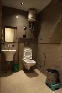 a bathroom with a toilet and a sink at Sukajini Home Stay & PG in Faridabad