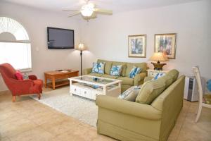 CupecoyTranquil Oceanside: Pools & Direct Beach Access的有两张沙发和一台电视的客厅