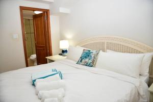 CupecoyTranquil Oceanside: Pools & Direct Beach Access的卧室里有一张白色的床，床上放着毛巾 更多37张照片