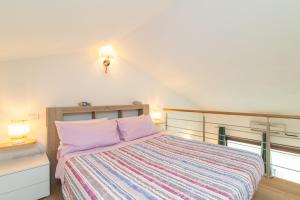 a bedroom with a large bed with a striped blanket at Casa Corallo in Palau