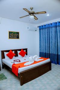 a bedroom with a large bed with red pillows at Villa viola resort in Marawila +7 photos