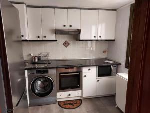 a kitchen with a washing machine and a microwave at Errotaetxe Mundaka in Mundaka