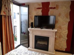 a living room with a fireplace with a tv on top at Errotaetxe Mundaka in Mundaka