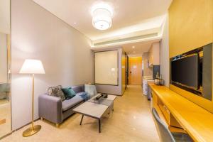 a living room with a couch and a flat screen tv at Fa万濠国际服务公寓 in Guangzhou