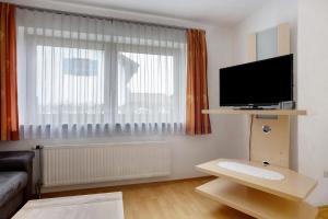 sala de estar con ventana grande y TV de pantalla plana en Ferienhaus Hilde, en Schwangau