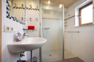 un baño con lavabo y ducha en Ferienhaus Hilde, en Schwangau 19 fotos más