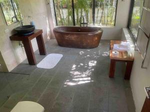 a bathroom with a large tub and two tables at Tranquil lake view villa on Phuket golf estate in Kathu +53 photos