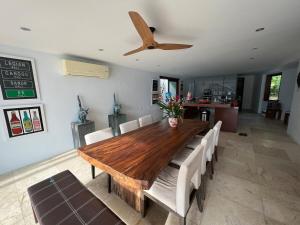 a dining room table with chairs and a ceiling fan at Tranquil lake view villa on Phuket golf estate in Kathu