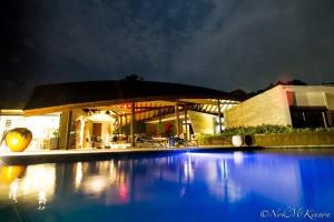 a swimming pool in front of a house at night at Tranquil lake view villa on Phuket golf estate in Kathu