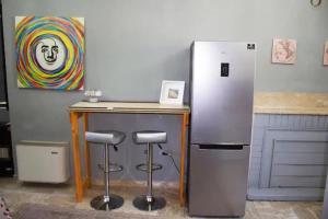 a kitchen with a refrigerator and a table and stools at Dogliola Monastery - B&B Hilltop Ocean View in Dogliola