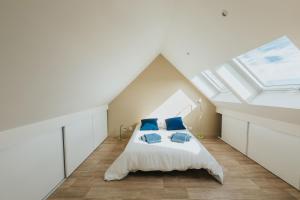 una camera da letto con un letto con cuscini blu di Maison de vacances à proximité de la plage a Saint-Pabu