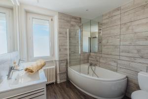 un bagno bianco con vasca e lavandino di Maison de vacances à proximité de la plage a Saint-Pabu Altre 32 foto