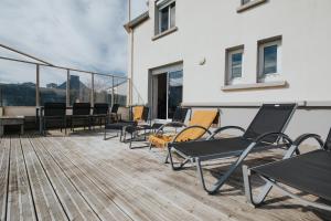una terrazza con sedie e tavoli su un edificio di Maison de vacances à proximité de la plage a Saint-Pabu