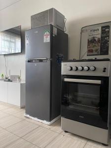 a refrigerator and an oven in a kitchen at Urban charm studio retreatt in Nairobi