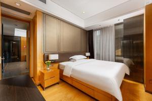 a bedroom with a large white bed and a bathroom at Fa万濠国际服务公寓 in Guangzhou