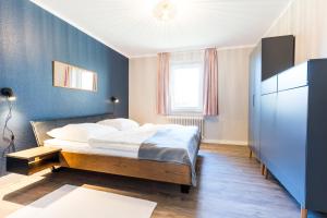 a bedroom with a bed and a blue wall at Am Hinrichsberg unten in Staberdorf +35 photos