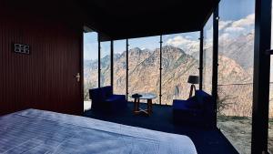 a bedroom with a bed and a view of mountains at We Are Made Of Stories in Joshīmath