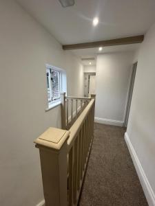 a hallway with a stairway with a wooden railing at Ironbridge town apartment in Ironbridge +15 photos