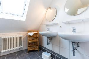 une salle de bain avec deux lavabos et un miroir dans l'établissement Am Hinrichsberg oben, à Staberdorf