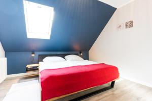 une chambre avec un lit rouge avec un mur bleu dans l'établissement Am Hinrichsberg oben, à Staberdorf 37 autres photos