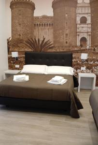 una camera da letto con un letto grande con due tavoli di Dante Relais a Napoli