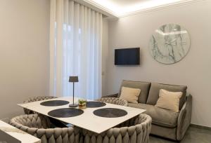 a living room with a table and a couch and a clock at Amabile Luxury Rooms in SantʼAntonio Abate