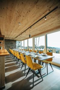 a long dining room with a long table and chairs at Le Noir Flohay 30 pers - Malmedy, vue, wellness in Malmedy