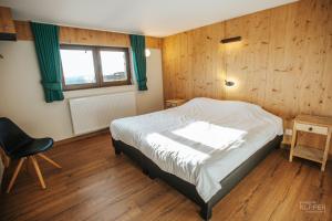 a bedroom with a bed and a chair and a window at Le Noir Flohay 30 pers - Malmedy, vue, wellness in Malmedy