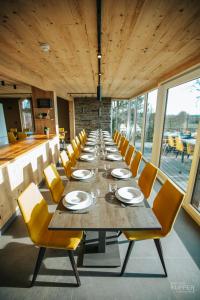 a long dining room with a long table and yellow chairs at Le Noir Flohay 30 pers - Malmedy, vue, wellness in Malmedy