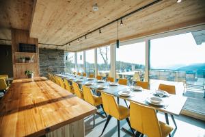 a long dining room with a long table and yellow chairs at Le Noir Flohay 30 pers - Malmedy, vue, wellness in Malmedy