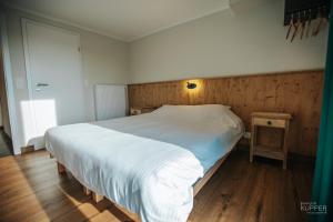 a bedroom with a large bed and a wooden wall at Le Noir Flohay 30 pers - Malmedy, vue, wellness in Malmedy