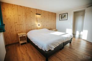 a bedroom with a bed with a wooden wall at Le Noir Flohay 30 pers - Malmedy, vue, wellness in Malmedy