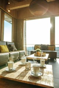 a living room with a coffee table with cups on it at Le Noir Flohay 30 pers - Malmedy, vue, wellness in Malmedy