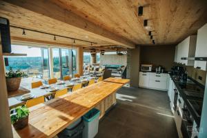 a large kitchen with a long wooden table and chairs at Le Noir Flohay 30 pers - Malmedy, vue, wellness in Malmedy