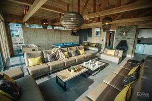 a living room with a couch and a pool table at Le Noir Flohay 30 pers - Malmedy, vue, wellness in Malmedy
