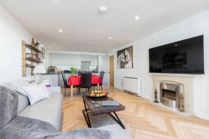 a living room with a white couch and a fireplace at Thornton House Town Centre Free Car Park in Cheltenham