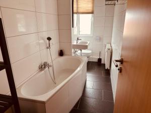 a white bathroom with a tub and a toilet at Aufladen & Entspannen im Senfzimmer mit Balkon in Gerwisch +10 photos