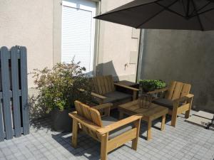 two chairs and a table and an umbrella on a patio at Maison Sorbier, Appartement 1 in Nevers +19 photos