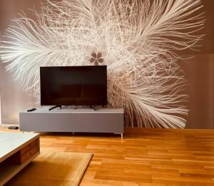 a living room with a tv and a large wall mural at Senfzimmer mit Balkon in Gerwisch